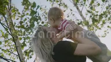 迷人的<strong>母亲</strong>抱着小儿子在怀里，俄罗斯桦树作为背景慢动作4k